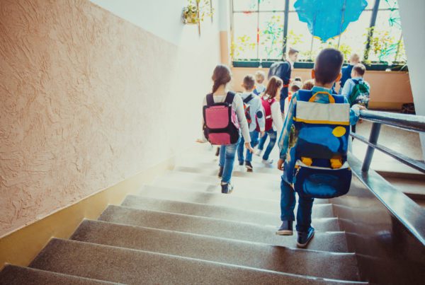 Children walking down the stairs in a school showing the importance of school safety