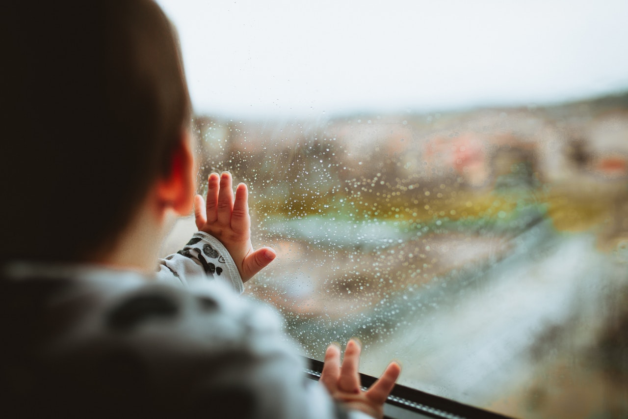 Child looking out a window in severe weather