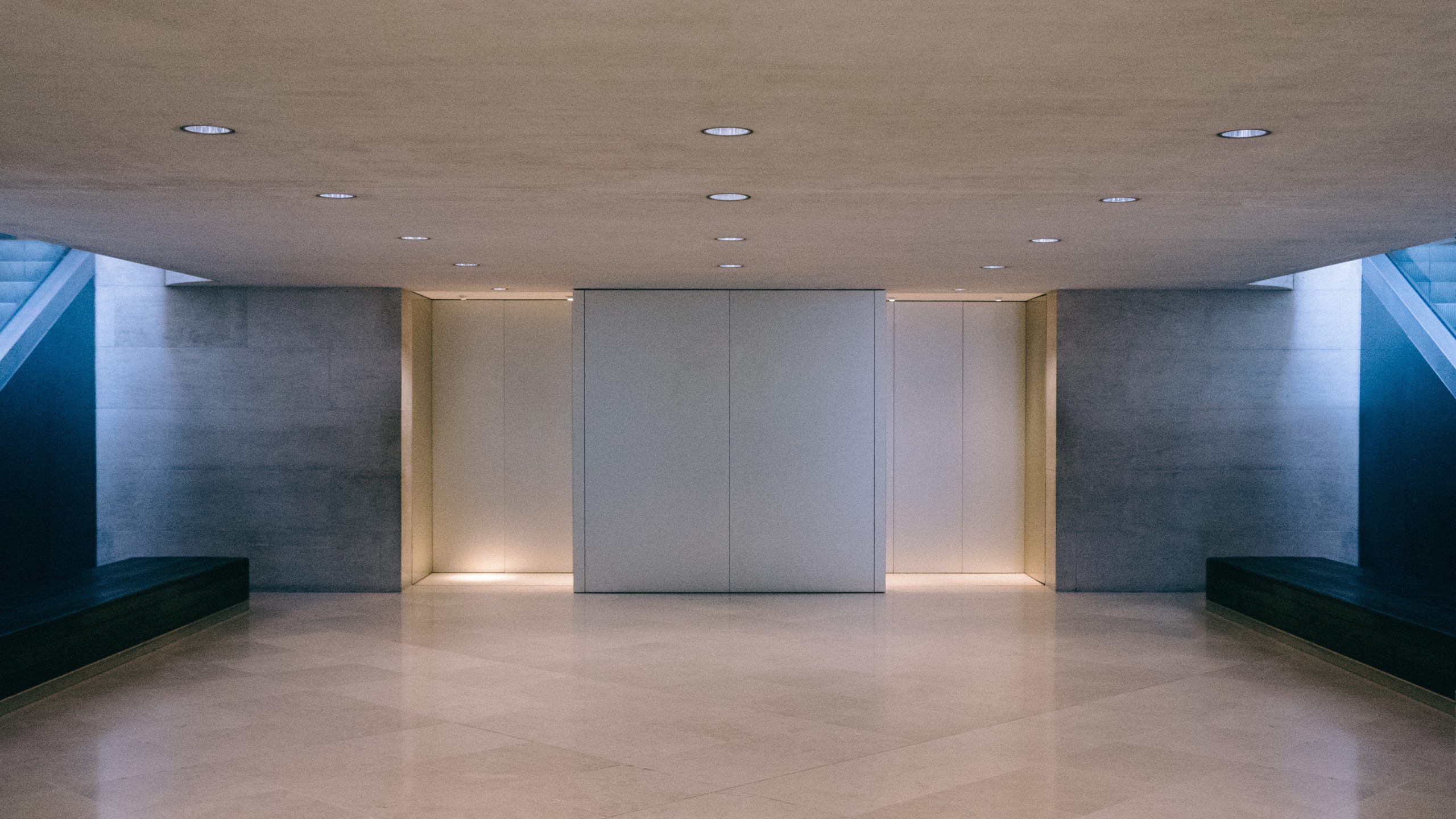White elevators in a lobby with belbien film