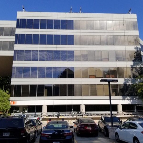 A large office building with half of the building installed with 3M film and the other not.
